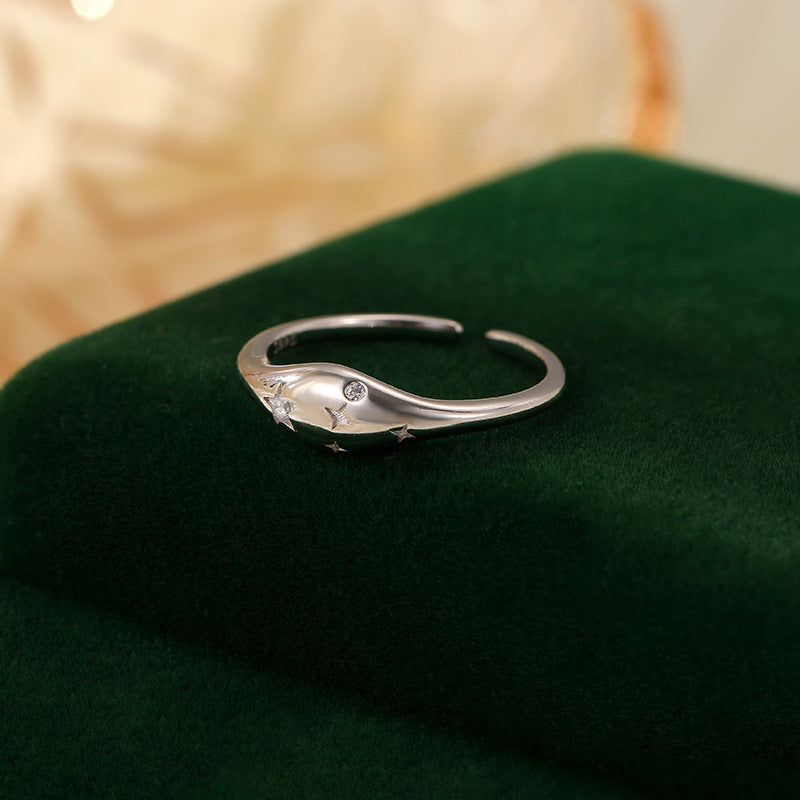 Bague femme argent ajustable avec design élégant et détails étoilés sur support vert