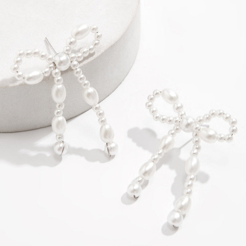 Boucles d'oreilles chic Moyyudé en perles blanches formant un noeud élégant pour un style raffiné