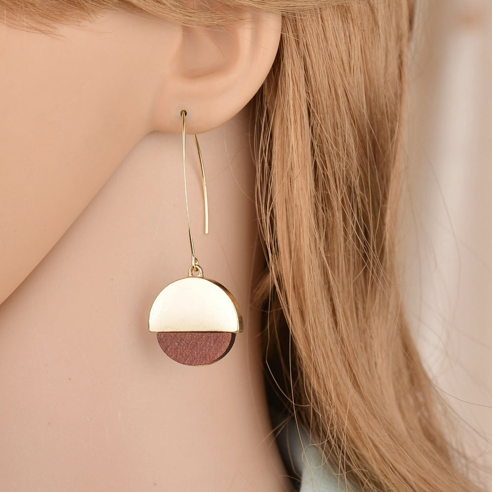 Boucles d'oreilles en bois chic Moyyudé avec pendentif demi-cercle doré et bois naturel porté à l'oreille