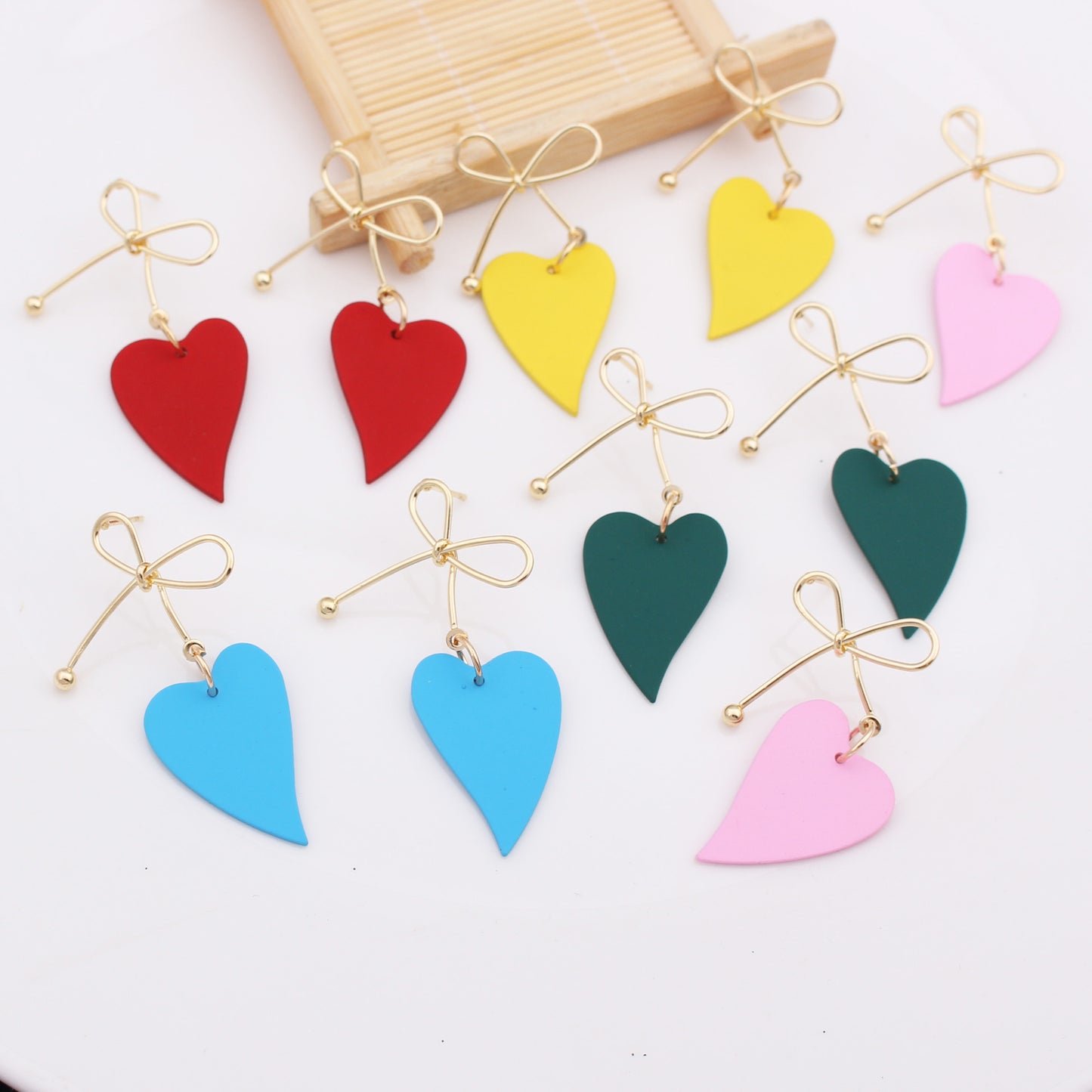 Boucles d'oreilles nœud papillon en métal doré avec cœurs colorés rouges jaunes bleus verts et roses Moyyudé