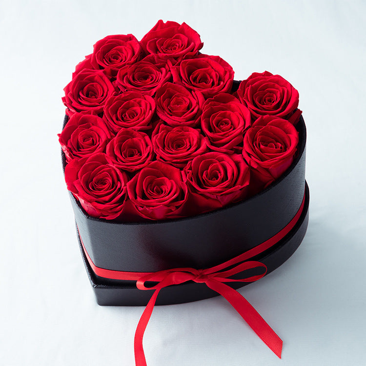 Pot de fleurs en cœur noir avec roses rouges séchées, décoré d'un ruban rouge Moyyudé