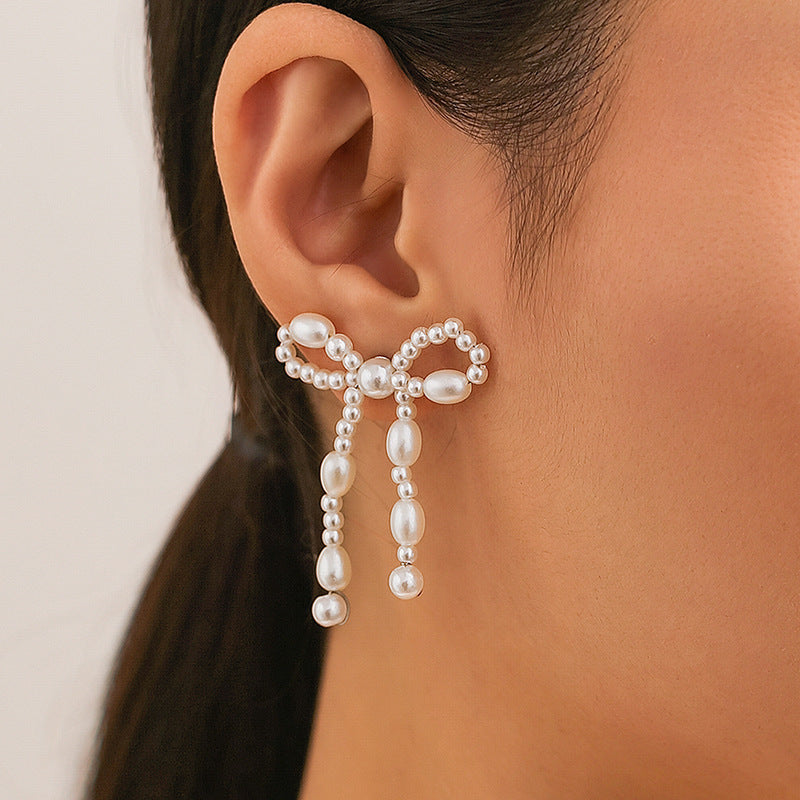 Boucles d'oreilles chic en perles blanches élégantes de la marque Moyyudé portées à l'oreille