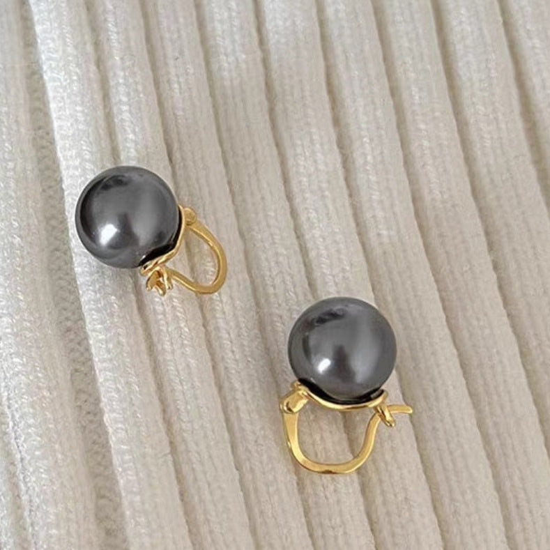 Boucles d'oreilles élégantes Moyyudé avec perles noires et attaches dorées sur tissu blanc