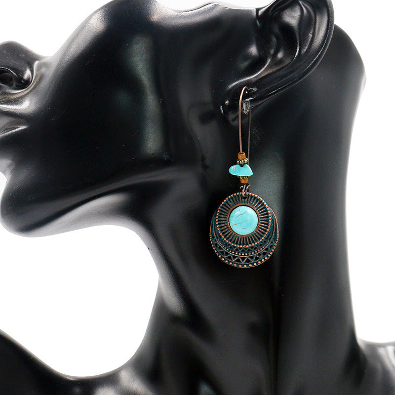 Boucles D'oreilles Vintage Turquoise pendantes avec design rond et détails en métal sur mannequin noir